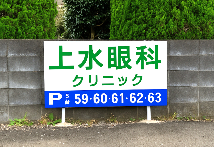 クリニック向かいの駐車場はこの看板が目印です。入って右側中ほどの59～63の駐車スペースをご利用ください。